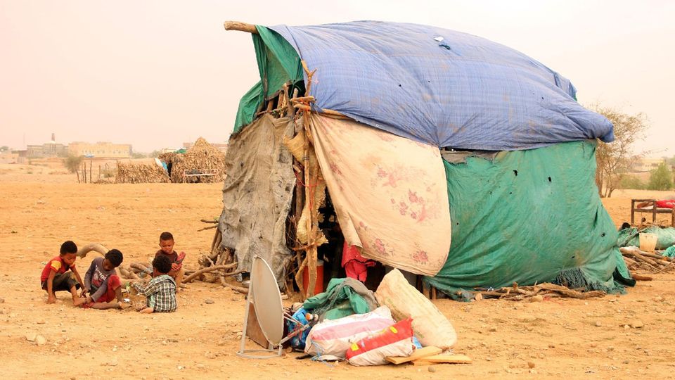 Flüchtlingskinder im Jemen spielen vor einem provisorischen Zelt aus rissigen Planen