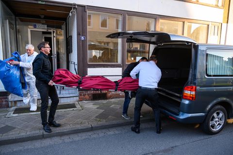 Bestatter schieben im niedersächsischen Wittingen einen Leichensack in einen Leichenwagen