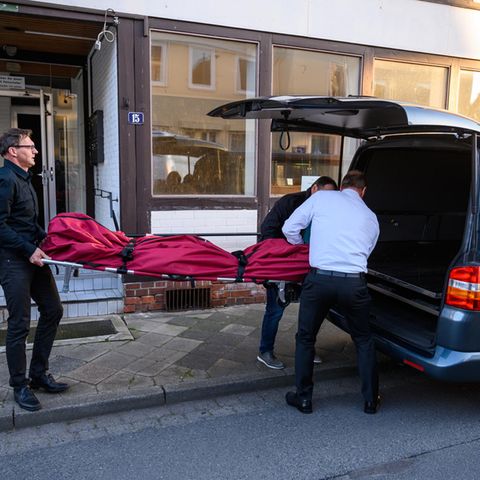 Bestatter schieben im niedersächsischen Wittingen einen Leichensack in einen Leichenwagen