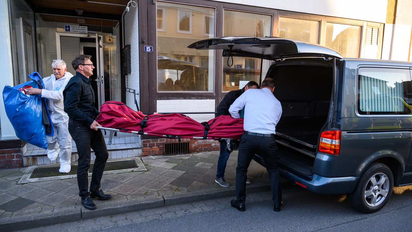 Bestatter schieben im niedersächsischen Wittingen einen Leichensack in einen Leichenwagen