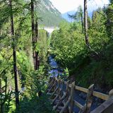Durch Lärchenwälder und dicht an rauschenden Bächen geht es hinab. Auf mehreren Ebenen kann man die Züge beobachten: Plötzlich verschwinden sie in einem Tunnel und tauchen nach mehreren Minuten der Stille viel weiter oben im Tal auf einem anderen Streckenabschnitt wieder auf.