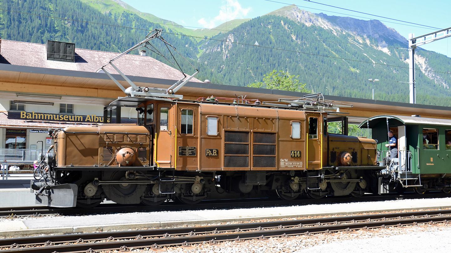 Nach acht Kilometern ist der Bahnhof von Bergün erreicht, wo gerade eine legendäre Lokomotive einen Nostalgiezug mit geschlossen Personen- und offenen Aussichtswagen zieht: das Krokodil. Im Hintergrund ist das Bahnmuseum Albula zu sehen.