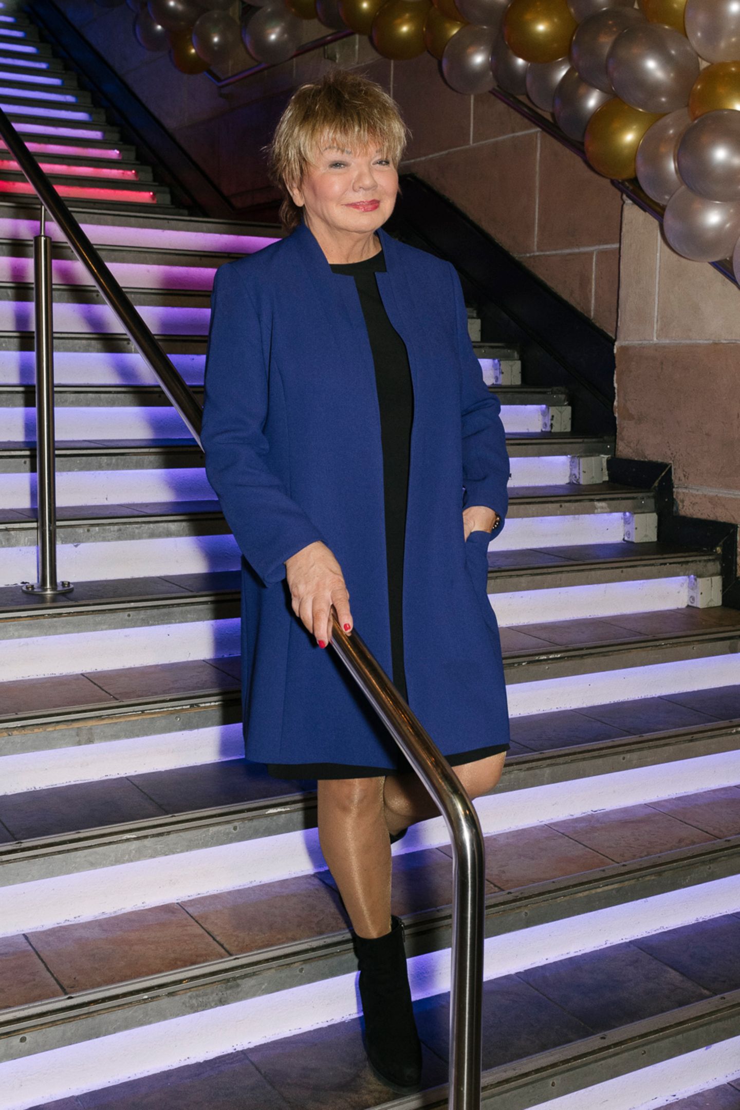 Kassenchefin Bärbel Schefberger des Praters steht an einer Treppe im blauen Mantel