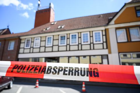 Hinter Flatterband mit "Polizeiabsperrung" steht ein hellgelbes Fachwerkhaus