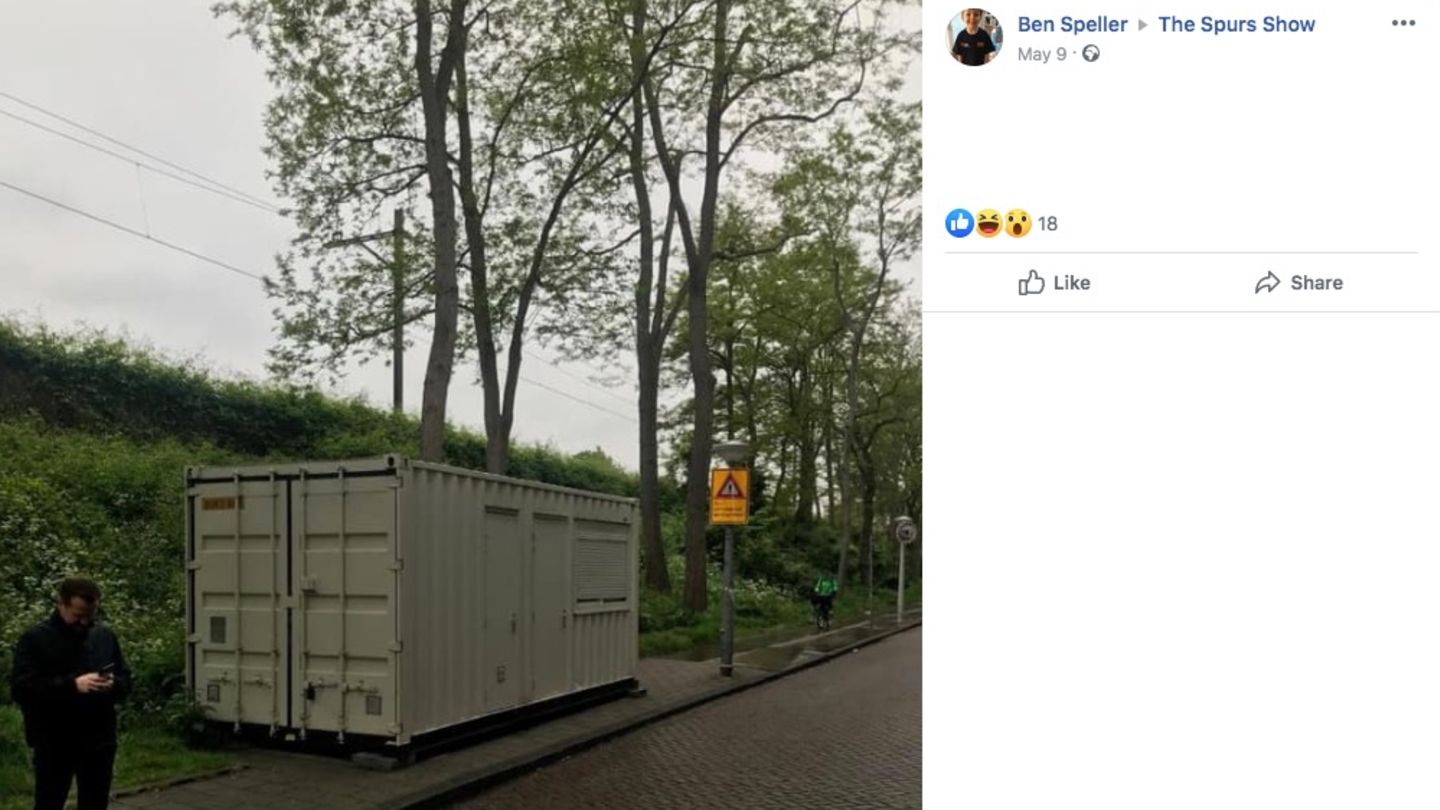 Ein Mann steht neben einem am Straßenrand stehenden Container