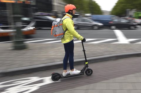Ein Frau fährt mit einem E-Roller auf einem Fahrradweg in Brüssel. In vielen europäischen Metropolen sind E-Scooter schon im Einsatz. In Deutschland entscheidet jetzt der Bundesrat über ihre Zulassung.