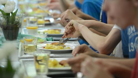 Mehrere Kinder sitzen beisammen und essen gemeinsam