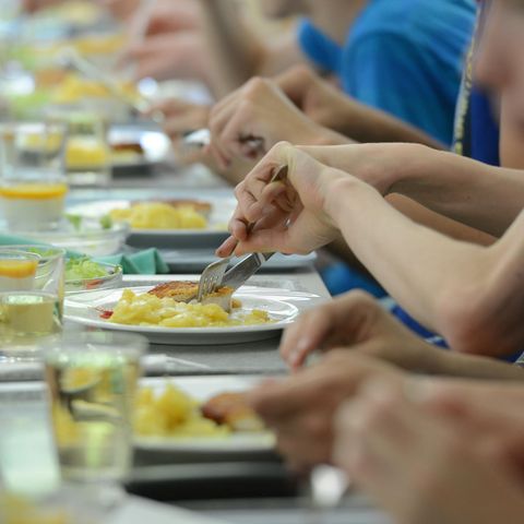 Mehrere Kinder sitzen beisammen und essen gemeinsam