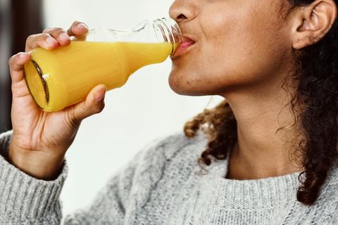 Gesundheitsgefahren von Fruchtsäften: Eine Frau trinkt Orangensaft