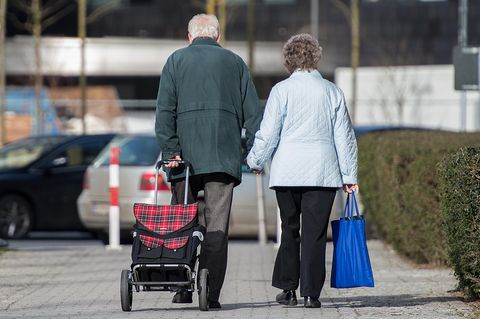 Ein älteres Ehepaar geht gemeinsam Hand in Hand