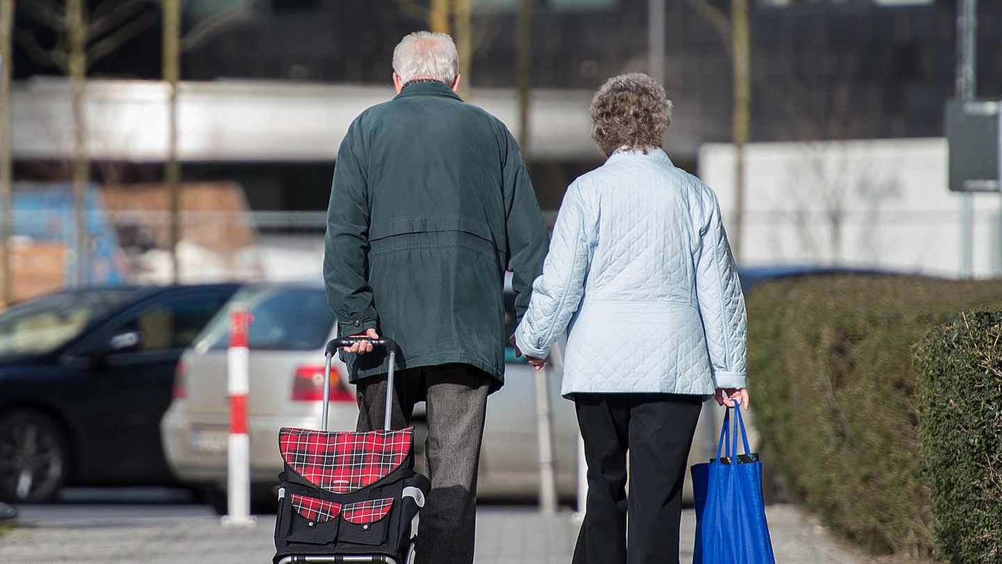Ein älteres Ehepaar geht gemeinsam Hand in Hand