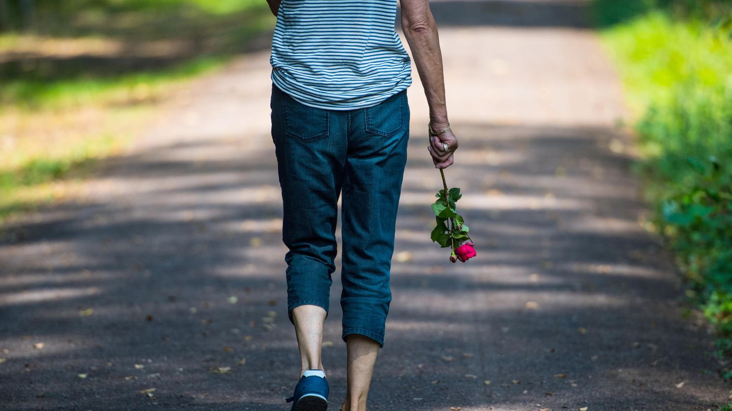 Eine Frau trägt eine rote Rose