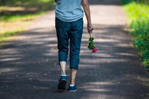 Eine Frau trägt eine rote Rose