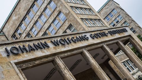 Der Haupteingang des Campus Westend mit der Aufschrift "Johann Wolfgang Goethe-Universität". Die Häuser sind aus hellem Stein.