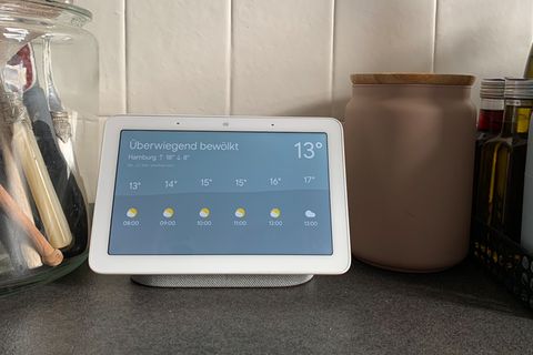 Ein Google Nest Hub auf einer Arbeitsfläche einer Küche. Auf dem Bildschirm sieht man die Wetteranzeige.
