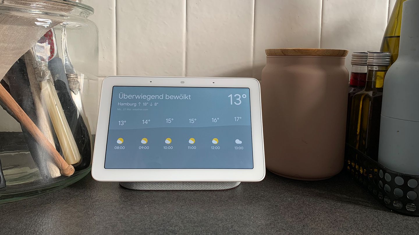 Ein Google Nest Hub auf einer Arbeitsfläche einer Küche. Auf dem Bildschirm sieht man die Wetteranzeige.