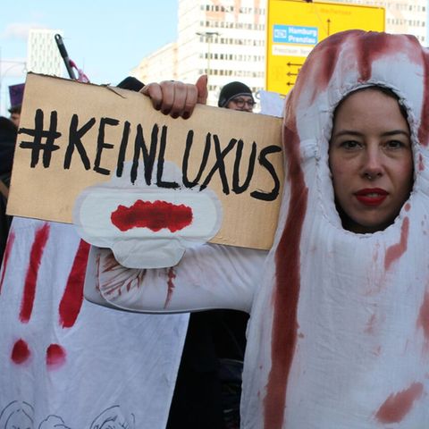 Frau mit #keinluxus Schild