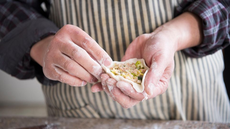 Dumplings füllen Dumplings in der Hand halten und mit Hackfleisch füllen
