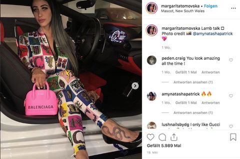 Die Influencerin sitzt in teurer Designer-Garderobe in einem Luxusauto