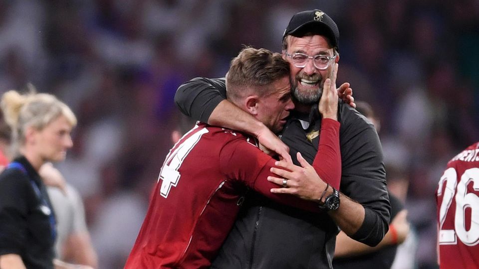 Jürgen Klopp umarmt im Moment seines größten Erfolges Liverpool-Kapitän Jordan Henderson