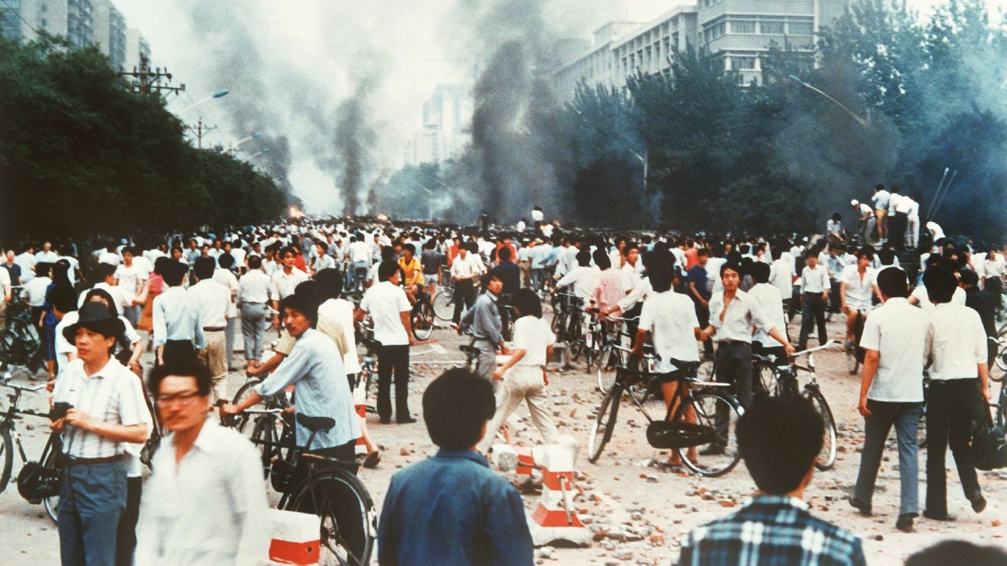 Rauchsäulen, Verwüstung und ratlose Menschen auf der Changan Avenue nahe dem Tian'anmen in Peking am 4. Juni 1989