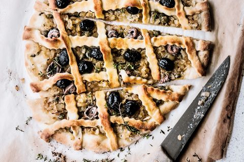 Eine Pizza auf Zwiebelbasis, mit salzwürzigen Akzenten und dekorativem Teiggitter