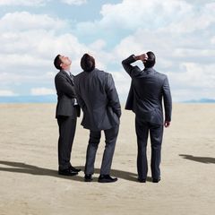 Männer im Anzug schauen in den Himmel