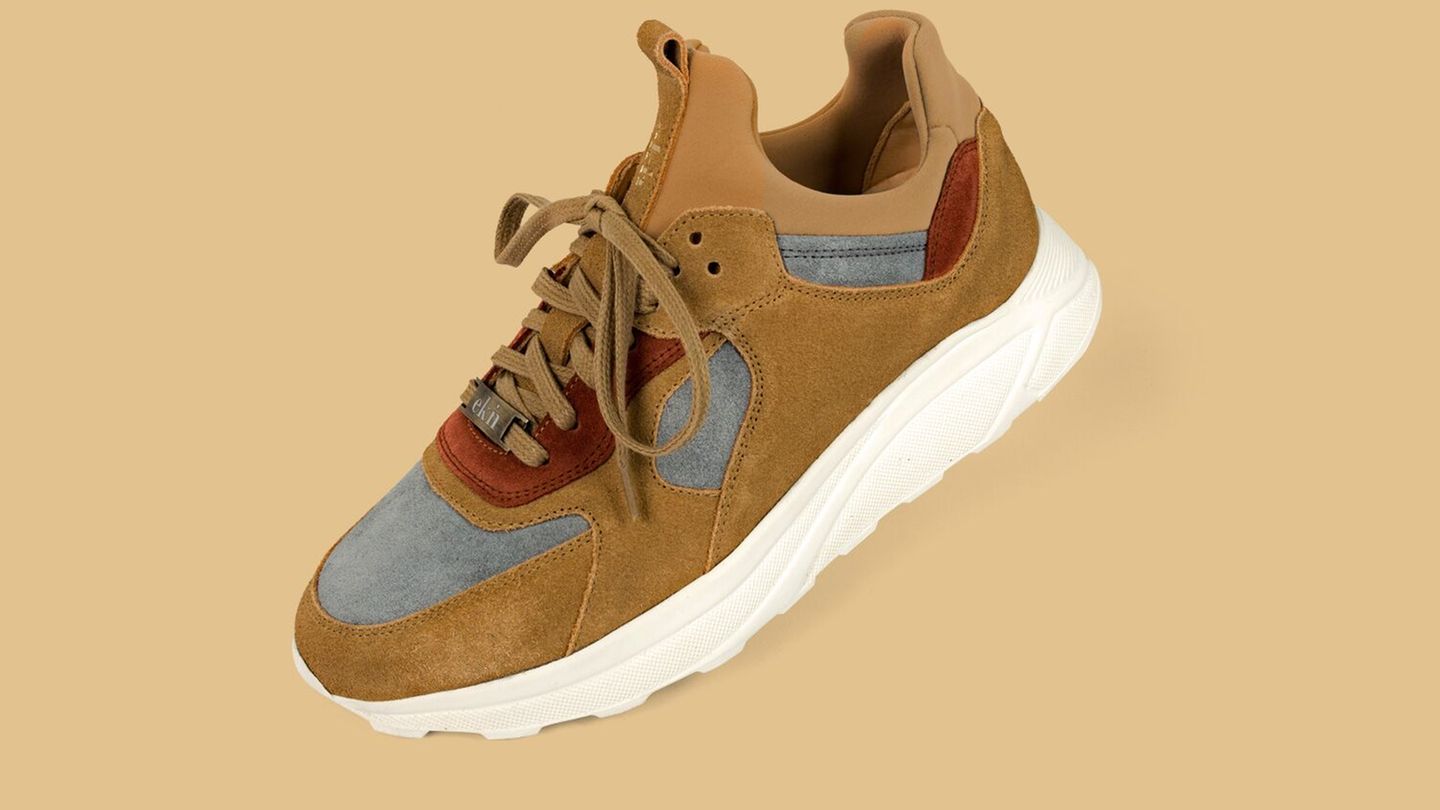 Ekn Footwear vereint Nachhaltigkeit mit schickem Design. Schwarzer Schuh auf grünem Hintergrund.