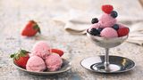 Beeren-Milcheis      Zutaten:  135 g Zucker, 15 g Glukosepulver, 1,5 g Johannisbrotkernmehl, 280 ml frische Vollmilch, 250 ml flüssige Sahne (32% Fettgehalt), 500 g geputzte gemischte Beeren      Zubereitung:  Den Zucker, das Glukosepulver und das Johannisbrotkernmehl vermischen. Die Milch und die Sahne in einen Topf geben, die trockenen Zutaten mit einem Schneebesen einrühren und die Mischung unter Rühren erhitzen, aber nicht aufkochen. Den Topf vom Herd ziehen und mit einem Stabmixer gut durchmixen. Die Grundmasse abkühlen lassen und anschließend im Kühlschrank kalt stellen. Die Beeren in einem Mixbecher mit dem Stabmixer fein pürieren. Das Püree durch ein Sieb streichen. Es werden 350 g Püree benötigt. Die Eisgrundmasse aus dem Kühlschrank nehmen. Das Beerenpüree unterrühren und mit dem Stabmixer gut durchmixen. Die Eisgrundmasse in die Eismaschine umfüllen und nach den Angaben des Herstellers ein cremiges Eis daraus herstellen. Das fertige Eis in einen vorgekühlten, verschließbaren Becher umfüllen, diesen mit dem Deckel verschließen und in das Gefrierfach stellen.