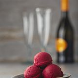 Cassis-Prosecco-Sorbet      Zutaten:  150 g Zucker, 30 g Glukosepulver, 1 g Johannisbrotkernmehl, 300 g schwarze Johannisbeeren, 40 g frisch gepresster Zitronensaft, 200 ml Prosecco      Zubereitung:  Den Zucker, das Glukosepulver und das Johannisbrotkernmehl vermischen. 280 ml Wasser und die schwarzen Johannisbeeren in einen Topf geben. Die trockenen Zutaten mit einem Schneebesen einrühren. Die Flüssigkeit unter Rühren erhitzen, aber nicht aufkochen, bis sich der Zucker vollständig aufgelöst hat. Den Topf vom Herd ziehen und den Topfinhalt abkühlen lassen. Dann alles mit einem Stabmixer durchmixen und das Püree abkühlen lassen. Das Püree nach Belieben durch ein feines Sieb streichen. Den Zitronensaft unterrühren. Die Sorbetmasse im Kühlschrank gut durchkühlen lassen. Die Sorbetmasse mit dem Stabmixer nochmals aufmixen, in die Eismaschine umfüllen und nach den Angaben des Herstellers ein cremiges Sorbet daraus herstellen. Sobald das Sorbet beginnt fest zu werden, den Prosecco dazugießen und das Sorbet fertigstellen. Das fertige Sorbet in einen verschließbaren Behälter füllen, diesen mit dem Deckel verschließen und zum Durchkühlen in den Kühlschrank stellen.