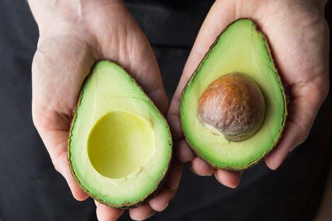 Avocadokern mitessen: Ein Mann hält eine aufgeschnittene Avocado in der Hand