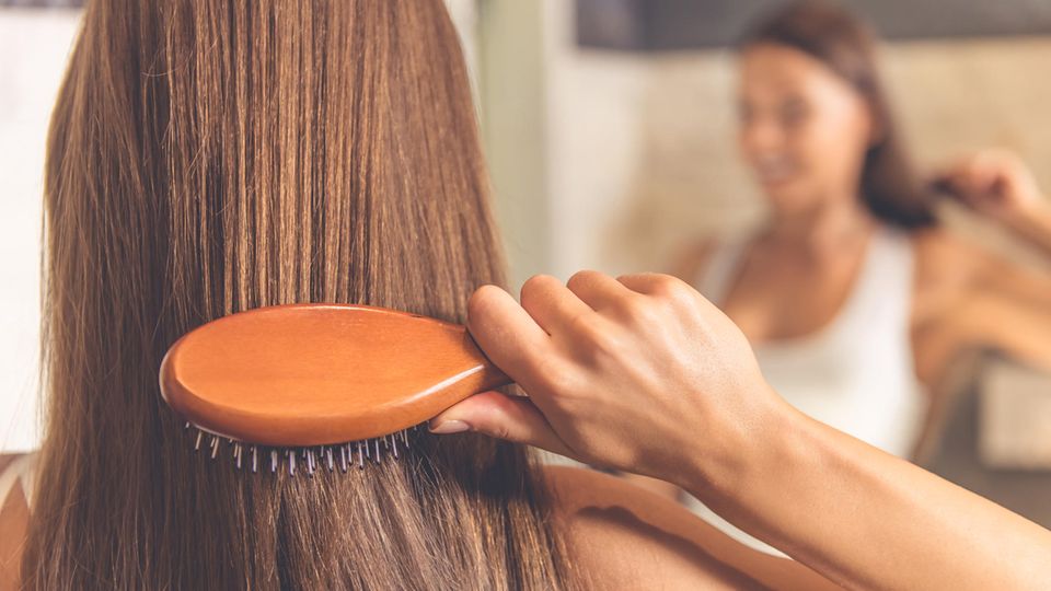 Lange Haare regelmäßig bürsten Frau bürstet ihre Haare