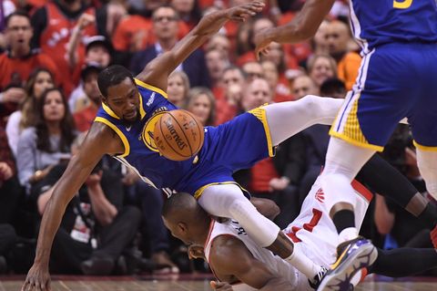 Kevin Durant (l.) von den Golden State Warriors fällt über den Toronto Raptors-Spieler Serge Ibaka