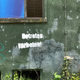 "Betreten verboten!" steht auf der Außenwand eines Gebäudes. Teile der Gebäude sind baufällig. Feuchtigkeit, aber auch Vandalismus setzen ihnen zu.