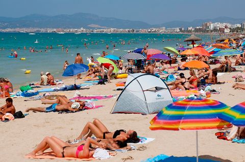 Ein Bild aus der Sommersaison 2018: Touristen sonnen sich am Strand von El Arenal