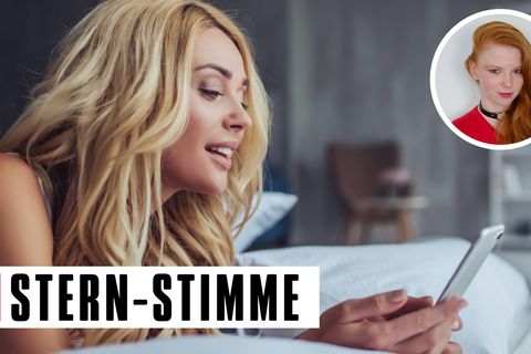 Attraktive junge Frau liegt zu Hause im Bett mit einem Smartphone in der Hand.