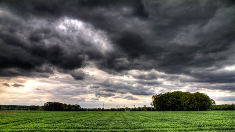 Ein Feld und Gewitterwolken