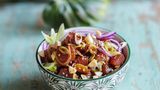 Ahi Poke - Thunfischsalat  300 g Thunfisch (Sashimiqualität), 1 kleine rote Zwiebel, 2 Frühlingszwiebeln, 1 EL Macadamianusskerne, 2 TL Sesam, 2 EL Sojasoße, 1 EL Sesamöl, 1 EL Sriracha (Chilisoße), 1 TL Honig, Salz      Zubereitung:  Den Thunfisch waschen und trocken tupfen, anschließend in mundgerechte Würfel von ca. 2 3 2 cm schneiden. Die Zwiebel schälen, halbieren und in dünne Streifen schneiden. Die Frühlingszwiebeln putzen, waschen und in feine Ringe schneiden. Die Nüsse grob hacken. Eine kleine Pfanne ohne Fett erhitzen. Nüsse und Sesam in der heißen Pfanne knapp 1 Minute goldbraun rösten, bis sie zu duften beginnen. Dann gleich aus der Pfanne nehmen, damit sie durch die Resthitze nicht verbrennen, und abkühlen lassen.      Den Fisch mit je der Hälfte der Zwiebeln, der Nüsse und des Sesams in eine Schüssel geben. Sojasoße, Öl, Sriracha und Honig dazugeben und alles miteinander vermischen. Der Fisch soll von einer glänzenden Schicht aus Marinade überzogen sein. Nach Belieben mit etwas Salz abschmecken und in zwei Schalen abfüllen. Mit restlichen Zwiebeln, Nüssen und Sesam bestreuen und servieren.