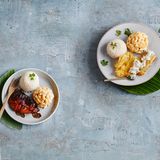 Mahi Mahi Plate Lunch  Für den Makkaronisalat: 200 g Mayonnaise, 200 ml Milch, 1 EL Rohrohrzucker, Salz | Pfeffer, 200 g Hörnchennudeln, 3 EL Apfelessig, 1 kleine Möhre, 50 g Sellerie, 1 kleine Zwiebel  Für den Reis:150 g Langkornreis, 380 ml Hühnerbrühe  Für die Tatarensosse: 1 kleine Gewürzgurke, 3 EL Mayonnaise, 1 EL gehackte Petersilie, Pfeffer  Für den Fisch: 1 Ei (M), 2 EL Mehl (Type 405), 2 Mahi-Mahi-Filets (à 180 g; Goldmakrele, wahlweise Kabeljau), Salz | Pfeffer | Rapsöl      Zubereitung:  Für den Salat in einem großen Topf ca. 1 l Wasser zum Kochen bringen. 100 g Mayonnaise, 150 ml Milch, Zucker, ½ TL Salz und 2 Prisen Pfeffer in eine große Schüssel geben und verrühren. Die Nudeln und 1 EL Salz ins kochende Wasser geben und in 15 Minuten weich kochen.      Die Nudeln abgießen, kurz trocken schütteln und wieder in den Topf geben. Sofort den Essig dazugeben und verrühren. 10 Minuten abkühlen lassen, anschließend in die vorbereitete Soße geben und verrühren, bis die Nudeln vollständig mit Soße überzogen sind. Die Nudeln abdecken und 2 Stunden in den Kühlschrank stellen.      In der Zwischenzeit Möhre, Sellerie und Zwiebel schälen und fein reiben. Mit restlicher Mayonnaise und Milch zum Nudelsalat geben und miteinander verrühren. Mit Salz und Pfeffer abschmecken und 2–4 Stunden, oder über Nacht, abgedeckt im Kühlschrank ziehen lassen. Vor dem Servieren nochmals mit Gewürzen abschmecken.      Für den Reis den Langkornreis in ein feines Sieb geben und unter fließendem kaltem Wasser abspülen, bis das Wasser klar wird. Die Brühe in einen mittelgroßen Topf geben und zum Kochen bringen. Den Reis einrühren, den Topf mit einem Deckel verschließen, die Hitze auf niedrige Stufe reduzieren und den Reis 20 Minuten kochen lassen. Den Topf beiseiteziehen und den Reis noch 5 Minuten ziehen lassen. Inzwischen für die Tatarensoße die Gewürzgurke fein hacken. Mit Mayonnaise und Petersilie in einer Schale verrühren und mit 1–2 Prisen Pfeffer abschmecken. In zwei Dip-Schälchen abfüllen.      Für den Fisch das Ei in einen tiefen Teller aufschlagen und verquirlen. Das Mehl in einen tiefen Teller geben. Den Fisch kalt abwaschen, trocken tupfen, salzen und pfeffern. 4 EL Öl in einer beschichteten Pfanne erhitzen. Den Fisch erst im Mehl wenden, überschüssiges Mehl abklopfen, dann im Ei wenden und anschließemd in der Pfanne bei mittlerer Hitze von beiden Seiten in ca. 2 Minuten goldbraun anbraten.      Eine halbrunde Tasse mit Öl einpinseln. Den Reis einfüllen und gut anpressen. Jeweils 2 Reiskugeln auf einen Teller stürzen. Ebenso 1 Kugel Nudelsalat daneben anrichten. Mit Fisch und Tatarensoße servieren