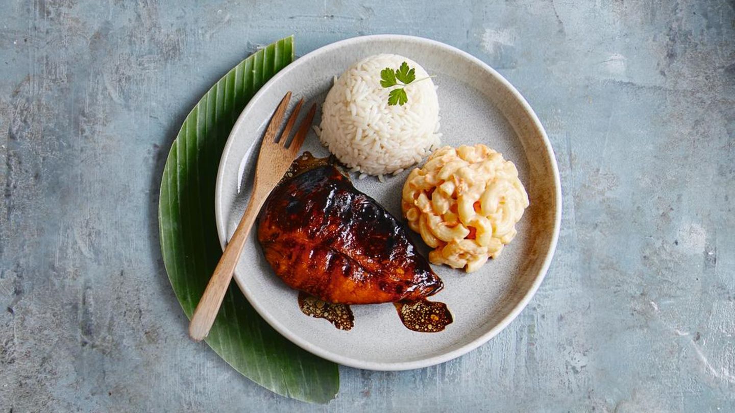 Mahi Mahi Plate Lunch  Für den Makkaronisalat: 200 g Mayonnaise, 200 ml Milch, 1 EL Rohrohrzucker, Salz | Pfeffer, 200 g Hörnchennudeln, 3 EL Apfelessig, 1 kleine Möhre, 50 g Sellerie, 1 kleine Zwiebel  Für den Reis:150 g Langkornreis, 380 ml Hühnerbrühe  Für die Tatarensosse: 1 kleine Gewürzgurke, 3 EL Mayonnaise, 1 EL gehackte Petersilie, Pfeffer  Für den Fisch: 1 Ei (M), 2 EL Mehl (Type 405), 2 Mahi-Mahi-Filets (à 180 g; Goldmakrele, wahlweise Kabeljau), Salz | Pfeffer | Rapsöl      Zubereitung:  Für den Salat in einem großen Topf ca. 1 l Wasser zum Kochen bringen. 100 g Mayonnaise, 150 ml Milch, Zucker, ½ TL Salz und 2 Prisen Pfeffer in eine große Schüssel geben und verrühren. Die Nudeln und 1 EL Salz ins kochende Wasser geben und in 15 Minuten weich kochen.      Die Nudeln abgießen, kurz trocken schütteln und wieder in den Topf geben. Sofort den Essig dazugeben und verrühren. 10 Minuten abkühlen lassen, anschließend in die vorbereitete Soße geben und verrühren, bis die Nudeln vollständig mit Soße überzogen sind. Die Nudeln abdecken und 2 Stunden in den Kühlschrank stellen.      In der Zwischenzeit Möhre, Sellerie und Zwiebel schälen und fein reiben. Mit restlicher Mayonnaise und Milch zum Nudelsalat geben und miteinander verrühren. Mit Salz und Pfeffer abschmecken und 2–4 Stunden, oder über Nacht, abgedeckt im Kühlschrank ziehen lassen. Vor dem Servieren nochmals mit Gewürzen abschmecken.      Für den Reis den Langkornreis in ein feines Sieb geben und unter fließendem kaltem Wasser abspülen, bis das Wasser klar wird. Die Brühe in einen mittelgroßen Topf geben und zum Kochen bringen. Den Reis einrühren, den Topf mit einem Deckel verschließen, die Hitze auf niedrige Stufe reduzieren und den Reis 20 Minuten kochen lassen. Den Topf beiseiteziehen und den Reis noch 5 Minuten ziehen lassen. Inzwischen für die Tatarensoße die Gewürzgurke fein hacken. Mit Mayonnaise und Petersilie in einer Schale verrühren und mit 1–2 Prisen Pfeffer abschmecken. In zwei Dip-Schälchen abfüllen.      Für den Fisch das Ei in einen tiefen Teller aufschlagen und verquirlen. Das Mehl in einen tiefen Teller geben. Den Fisch kalt abwaschen, trocken tupfen, salzen und pfeffern. 4 EL Öl in einer beschichteten Pfanne erhitzen. Den Fisch erst im Mehl wenden, überschüssiges Mehl abklopfen, dann im Ei wenden und anschließemd in der Pfanne bei mittlerer Hitze von beiden Seiten in ca. 2 Minuten goldbraun anbraten.      Eine halbrunde Tasse mit Öl einpinseln. Den Reis einfüllen und gut anpressen. Jeweils 2 Reiskugeln auf einen Teller stürzen. Ebenso 1 Kugel Nudelsalat daneben anrichten. Mit Fisch und Tatarensoße servieren