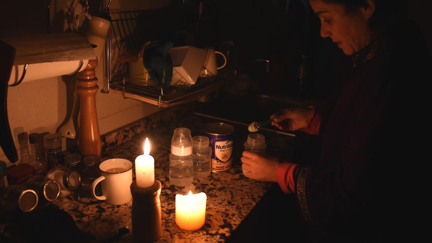 Das Leben bei Stromausfall: Bei Kerzenlicht macht diese Frau in Montevideo eine Milchflasche für ihr Baby fertig