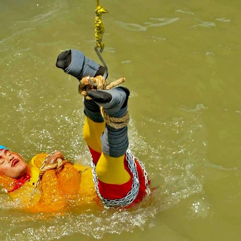 it einem Seil und Ketten gefesselt hat sich ein Zauberkünstler in Indien in den Ganges fallen lassen