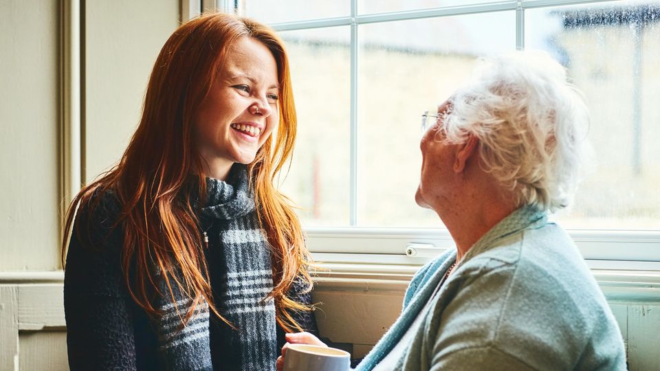 Ältere Dame und junge Frau lachen zusammen