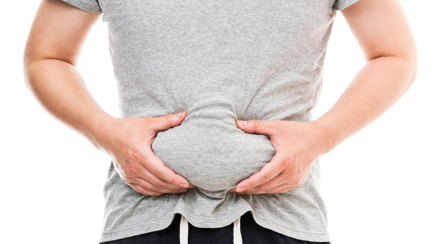 Ein Mann fasst seinen Bauch an