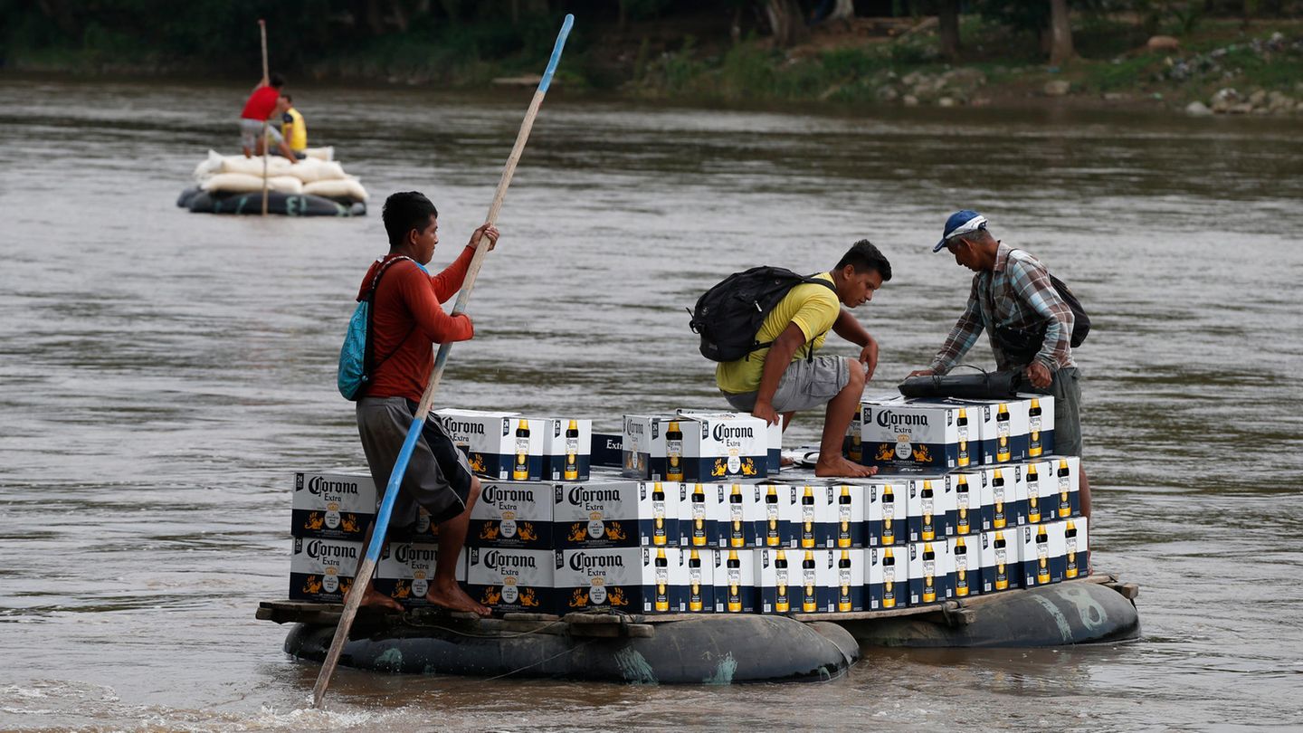 18. Juni: Damit das Bier fließt Flößer tragen eine Ladung Bier über den Rio Suchiate auf einem Schlauchboot