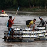 Flößer tragen eine Ladung Bier über den Rio Suchiate auf einem Schlauchboot