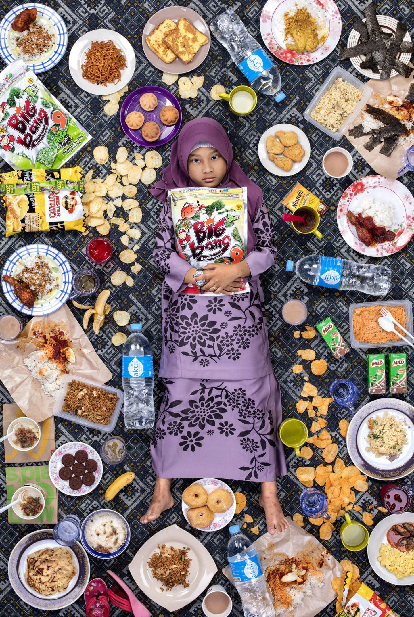 Daily Bread: Nur Zahra Alya Nabila Binti Mustakim, Kajang, Malaysia, 7 Jahre alt Auf Nurs Speiseplan stehen chinesische, indische und malaiische Gerichte wie Chee Cheong Fun, Reisnudelröllchen mit gedämpftem Tofu, Bohnenquark und Fischbällchen, die mit etwas süßer Chilipaste serviert werden. Roti Canai, ein Fladenbrot mit Dal und Curry; und Nasi Lemak, eine Mischung aus Reis, gekochten Eiern, Gurken, Sardellen, Erdnüssen und Sambal (scharfe Soße), in Kokosmilch gekocht und in Bananenblätter gewickelt. 90% der Mahlzeiten von Nur sind hausgemacht. Sie liebt das Essen ihrer Mutter, besonders ihre Nasa Ayam (Hühnchen und Reis). Das ungesündeste Essen, das Nur isst, sind die Snacks und süßen Getränke, die sie in ihrer Schulkantine kauft. Nur Zahra Alya Nabila Binti Mustakim, Kajang, Malaysia, 7 Jahre alt Auf Nurs Speiseplan stehen chinesische, indische und malaiische Gerichte wie Chee Cheong Fun, Reisnudelröllchen mit gedämpftem Tofu, Bohnenquark und Fischbällchen, die mit etwas süßer Chilipaste serviert werden. Roti Canai, ein Fladenbrot mit Dal und Curry; und Nasi Lemak, eine Mischung aus Reis, gekochten Eiern, Gurken, Sardellen, Erdnüssen und Sambal (scharfe Soße), in Kokosmilch gekocht und in Bananenblätter gewickelt. 90% der Mahlzeiten von Nur sind hausgemacht. Sie liebt das Essen ihrer Mutter, besonders ihre Nasa Ayam (Hühnchen und Reis). Das ungesündeste Essen, das Nur isst, sind die Snacks und süßen Getränke, die sie in ihrer Schulkantine kauft.