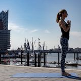 Frau in Sportklamotten beim Yoga.