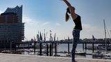 Frau in Sportklamotten beim Yoga.