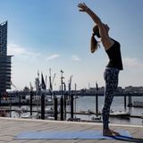 Frau in Sportklamotten beim Yoga.